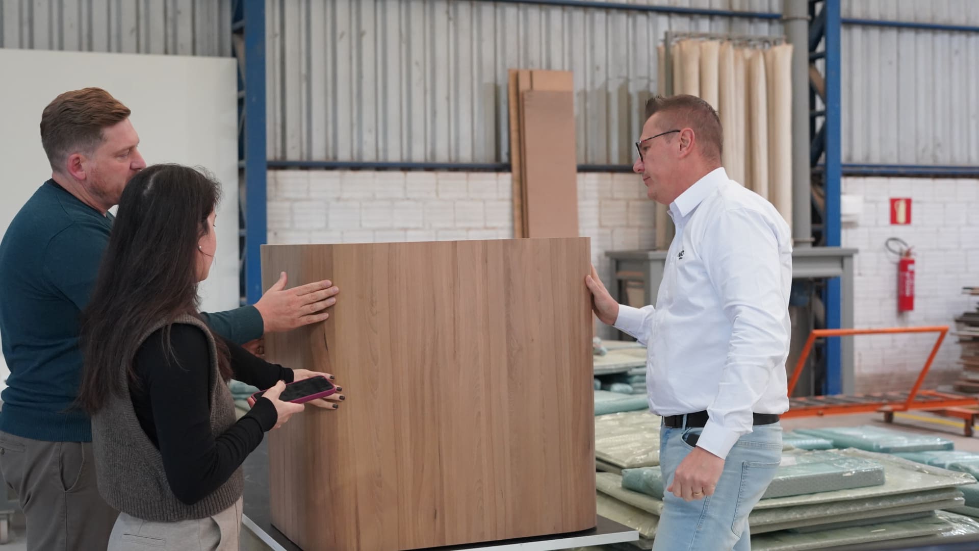 Equipe AFETTO em reunião com lojista parceiro analisando peça de móvel customizado na fábrica